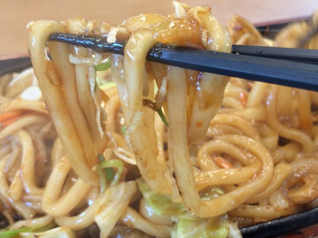 箸で焼うどんの麺を持ち上げている