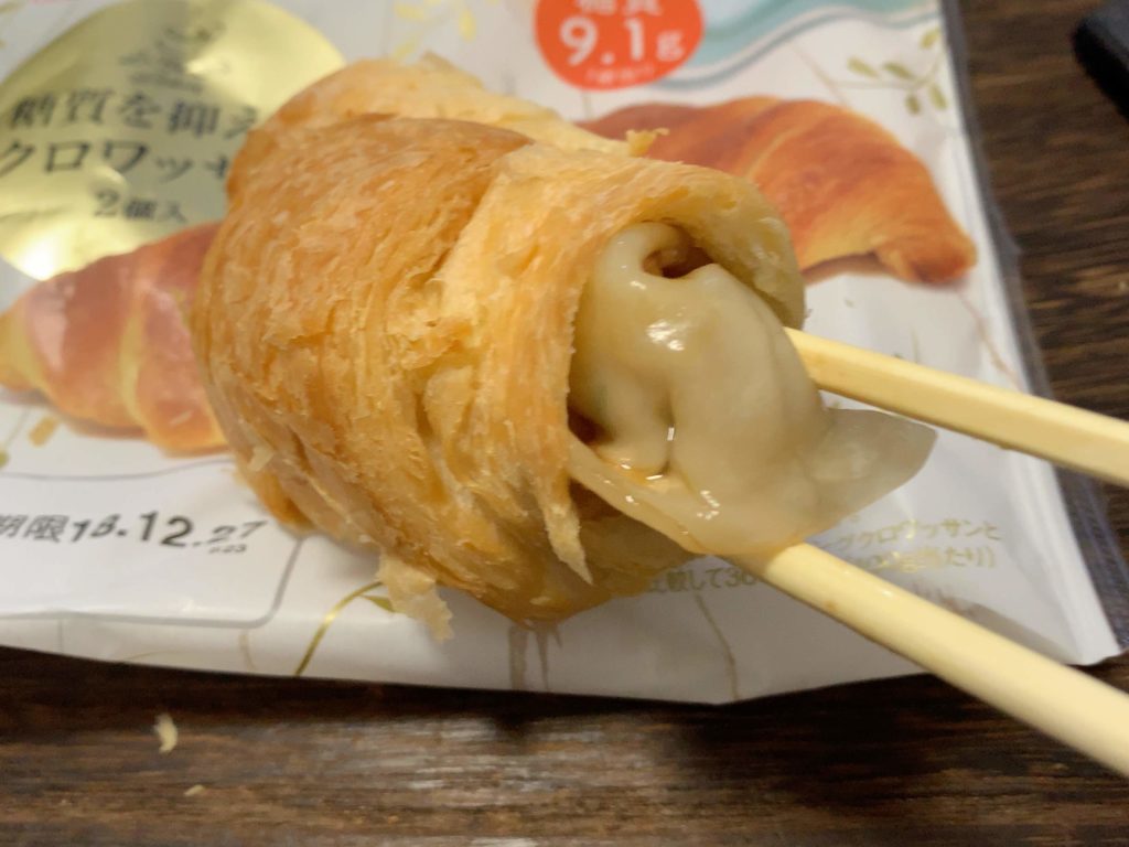 箸で餃子をクロワッサンに入れている