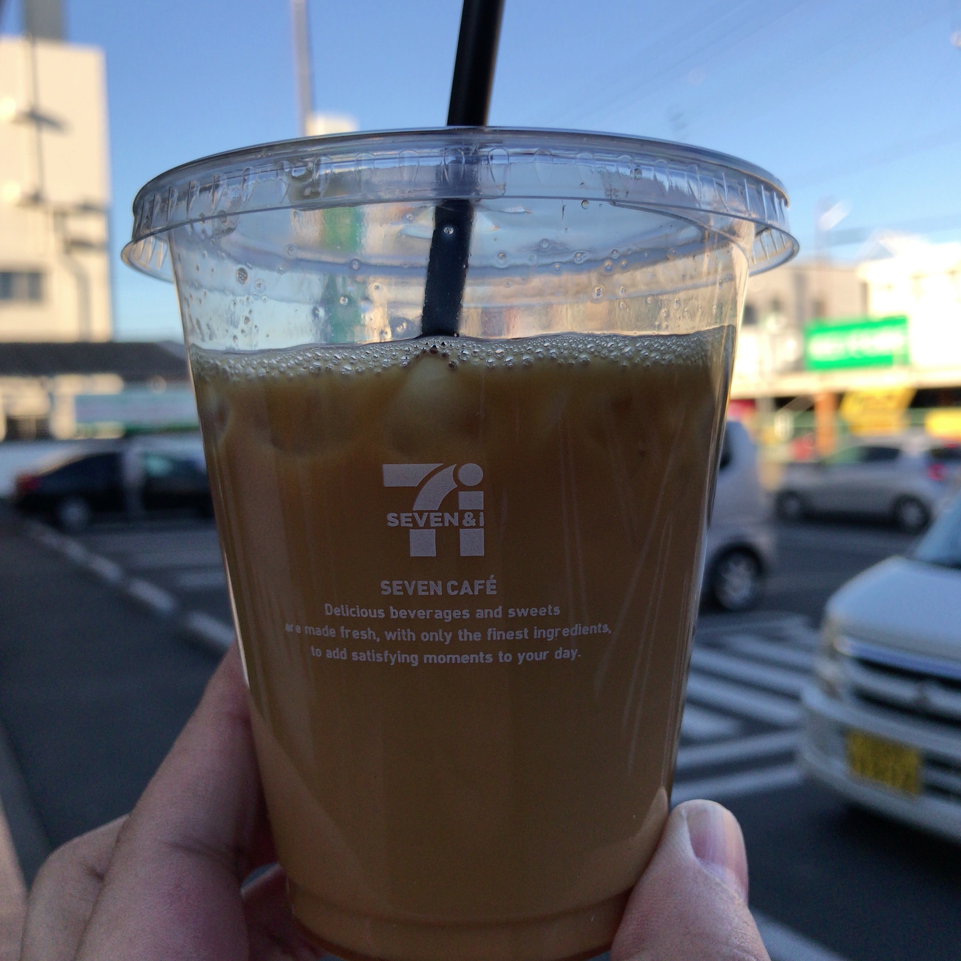 駐車場が背景のアイスコーヒー