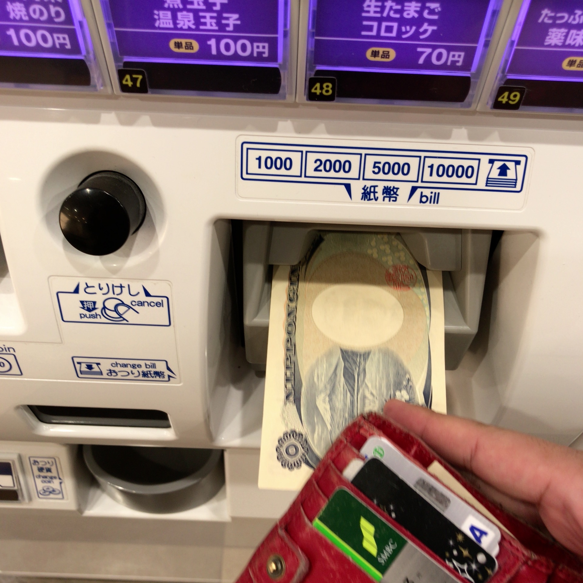 券売機にお金を入れている